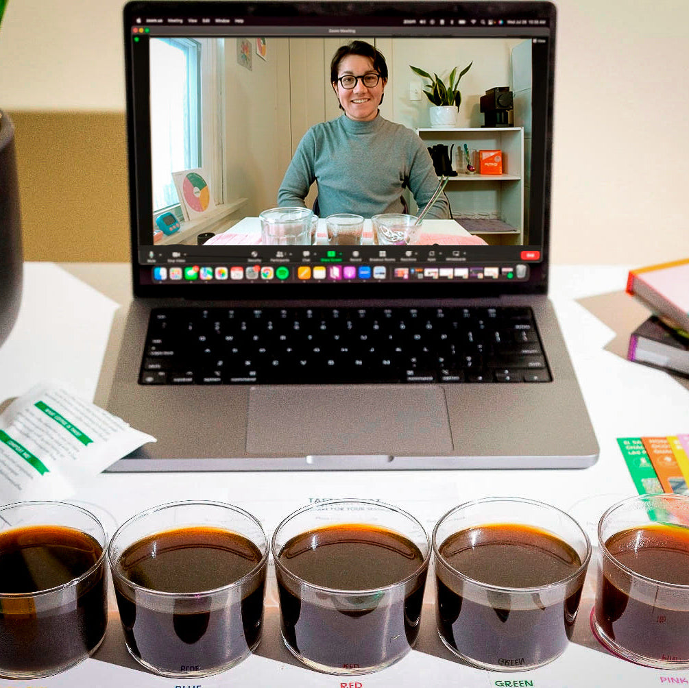 Laptop displaying a virtual tasting video call with five small cups of coffee on a table 